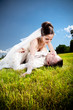 Young newly married couple lying on green lawn Young newly married couple lying on green lawn