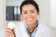 Beautiful female doctor using a stethoscope while looking at the