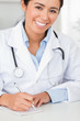 Good looking female doctor writing on a scratchpad