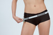 femme mesurant son ventre plat en boxer marron femme mesurant son ventre plat en boxer marron