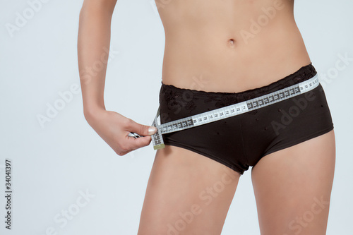Photo : femme mesurant son ventre plat en boxer marron femme mesurant son ventre plat en boxer marron