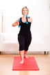 blonde Frau beim Aerobic im Wohnzimmer