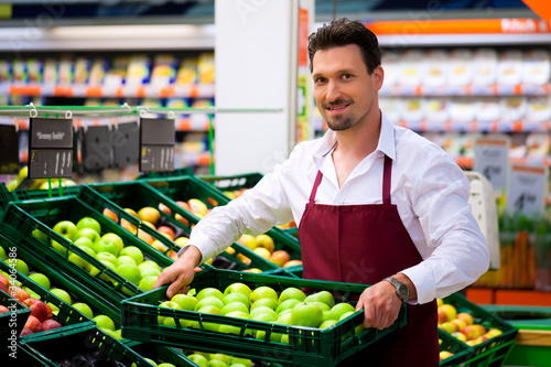 Photo: Man in supermarket as shop assistant Man in supermarket as shop assistant