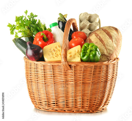 Photo: Groceries in wicker basket isolated on white Groceries in wicker basket isolated on white
