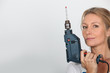 Blond woman holding electric drill