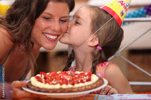 Photo: Daughter kissing mommy at birthday party Daughter kissing mommy at birthday party