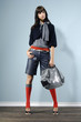 Fashion girl with handbag posing in the studio Fashion girl with handbag posing in the studio