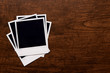 Empty instant photos on wooden table background