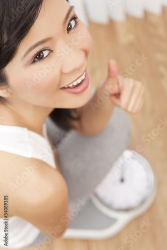 Photo: Asian Chinese Woman Thumbs Up Weighing Herself on Scales Asian Chinese Woman Thumbs Up Weighing Herself on Scales