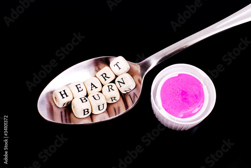 Photo: Heart Burn Spelled Out with Capful of Pink Medicine Heart Burn Spelled Out with Capful of Pink Medicine