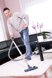 Living room cleaning vacuum cleaner, a young man.