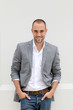 Handsome smiling man leaning on wall