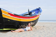 Young girl and a boat on the beach Young girl and a boat on the beach