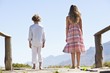 Rear view of siblings standing together at a pier