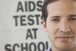 Photo: Close-up of a man in front of AIDS awareness poster Close-up of a man in front of AIDS awareness poster