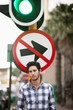 Man with "No Entry" sign and traffic light in the background