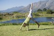 Cute little boy doing cartwheel against mountain
