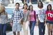 Friends walking on the sidewalk against cars