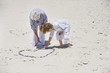Senior woman and her grandson making a heart shape on the beach