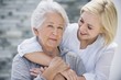 Young woman embracing her mother from behind