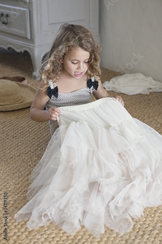 Photo: Cute little girl getting dressed like her mother in oversized clothes Cute little girl getting dressed like her mother in oversized clothes