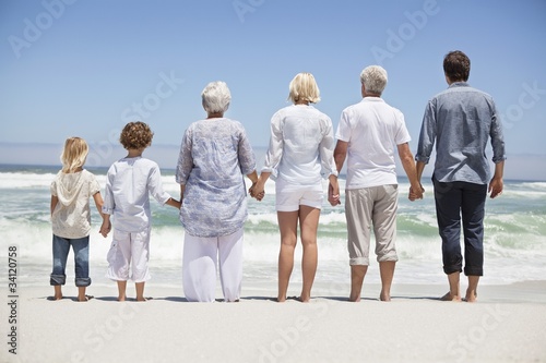 Photo: Rear view of a family looking at sea view from beach Rear view of a family looking at sea view from beach