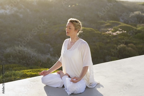Photo: Mid adult woman meditating Mid adult woman meditating