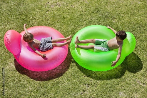 Photo: Two boys relaxing on inflatable rings Two boys relaxing on inflatable rings