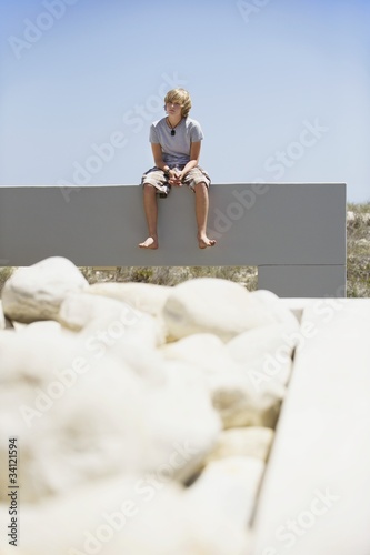 Photo: Teenage boy sitting at the edge of a terrace Teenage boy sitting at the edge of a terrace
