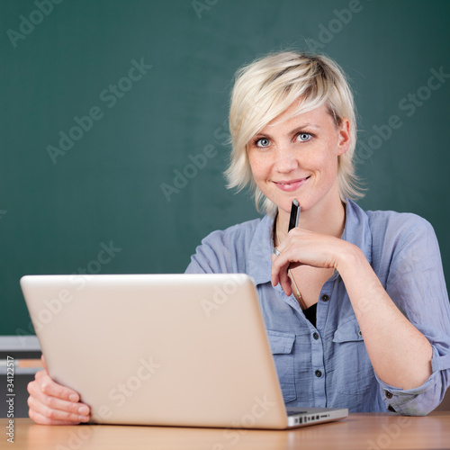 Photo: lächelnde junge frau lernt am laptop lächelnde junge frau lernt am laptop