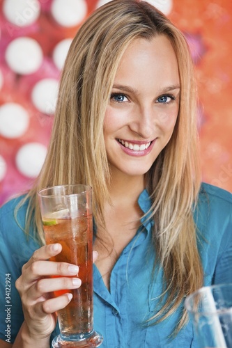Foto: Portrait of a beautiful woman having ice tea in a bar and smiling Portrait of a beautiful woman having ice tea in a bar and smiling
