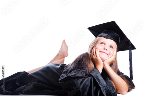 Photo: Dreaming girl in graduation dress on isolated white Dreaming girl in graduation dress on isolated white