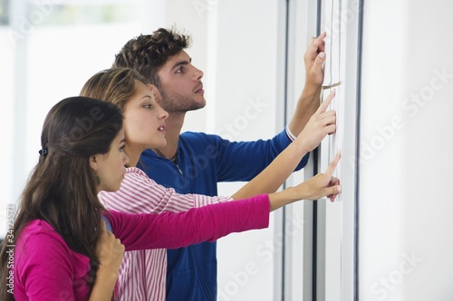 Photo: University students checking bulletin board for test result University students checking bulletin board for test result