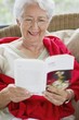 Senior woman reading a magazine and smiling