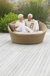 Senior couple sitting in a wicker couch