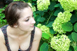 Beautiful girl sitting and enjoying flowers in the garden Beautiful girl sitting and enjoying flowers in the garden