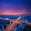 Freeway in night with cars light in modern city.
