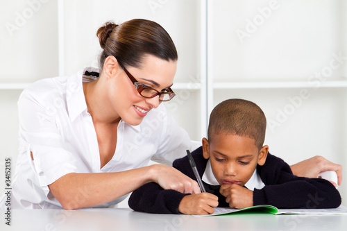Photo: teacher helping primary student teacher helping primary student