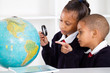 Photo: two elementary school students looking at globe two elementary school students looking at globe