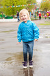 A girl is jumping in the puddle