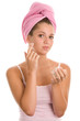 Woman applying cream on face