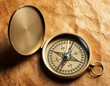 Close-up view of compass on vintage paper background Close-up view of compass on vintage paper background