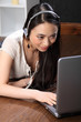 Asian girl with headphones using laptop