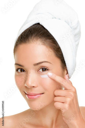 Photo: Skin care woman putting face cream Skin care woman putting face cream