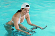 Jeune femme souriante faisant de l'aquabike