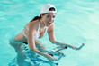 Jeune femme souriante faisant de l'aquabike