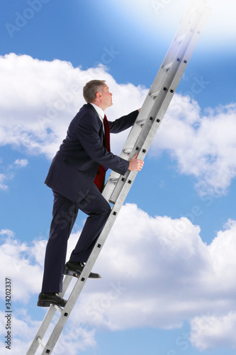 Photo: Businessman climbing a ladder in the sky Businessman climbing a ladder in the sky