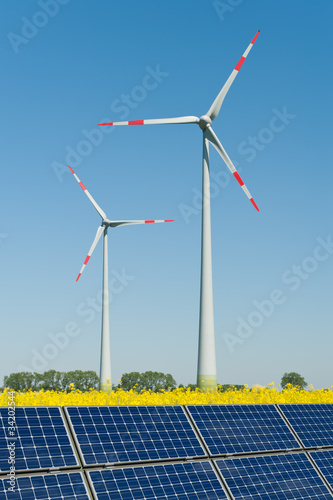 Foto: Solarmodule und Windkrafträder in einem Rapsfeld Solarmodule und Windkrafträder in einem Rapsfeld
