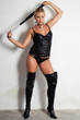beautiful woman on high heels holding a whip