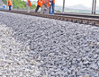 railway embankment, rails and workers in orange vests